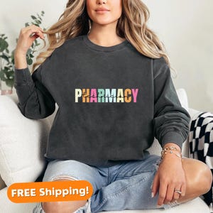 May include: A black sweatshirt with the text "PHARMACY Technician" in rainbow colours.
