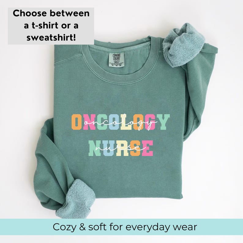 May include: A teal green sweatshirt with the words "ONCOLOGY NURSE" in colorful block letters. The sweatshirt is folded and has a tag that says "COMFORT COLORS".