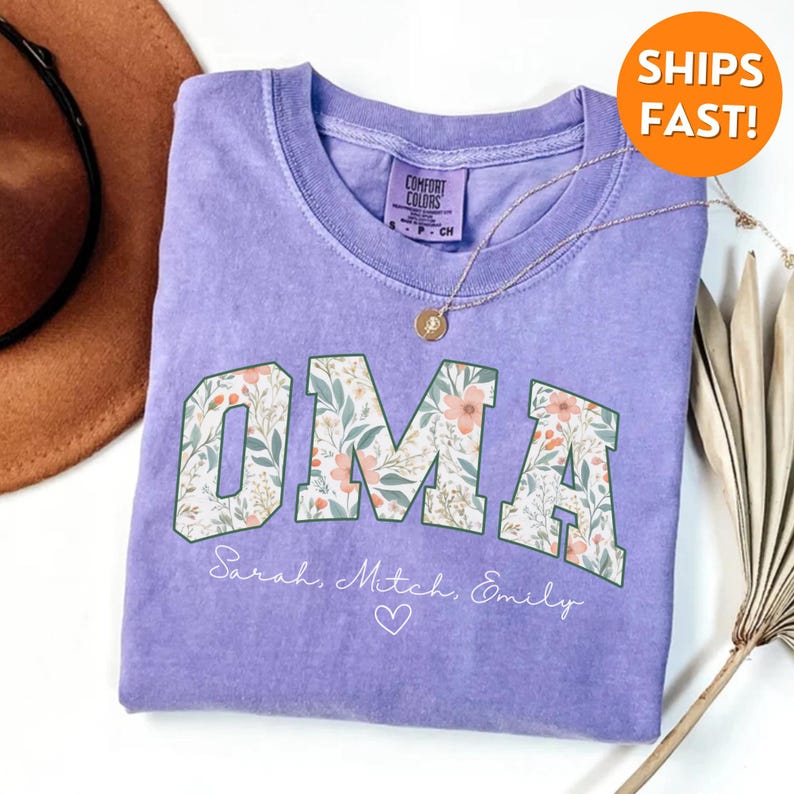 May include: A purple t-shirt with a floral print design that spells out "OMA" with the names "Sarah, Mitch, Emily" and a heart below.