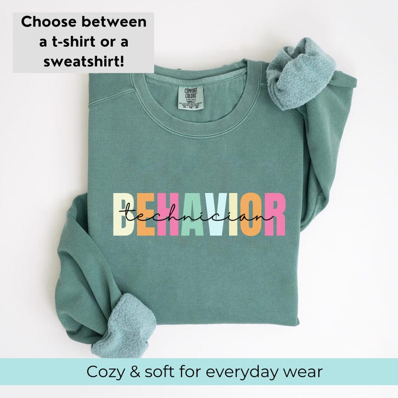May include: A teal green sweatshirt with the text "BEHAVIOR technician" in rainbow colors. The sweatshirt is folded and displayed on a white background.