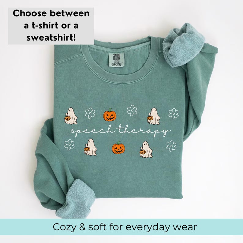 May include: A teal sweatshirt with the text "speech therapy" and Halloween-themed graphics. The design includes cartoon ghosts, pumpkins, and flowers. The top text reads "Choose between a t-shirt or a sweatshirt!" and the bottom text reads "Cozy & soft for everyday wear."