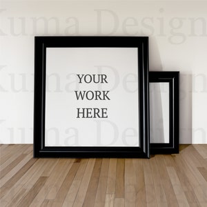 Könnte beinhalten: Zwei schwarze Bilderrahmen auf einem Holzboden. Der größere Rahmen ist leer mit dem Text "YOUR WORK HERE" darin. Der kleinere Rahmen ist ebenfalls leer.