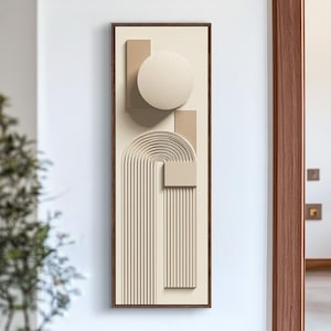 May include: Abstract wall art in a rectangular wooden frame. The artwork features a beige background with raised geometric shapes, including a circle, rectangles, and a curved arch design. The color palette is neutral, with shades of beige and brown.