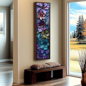 Pode incluir: Uma obra de arte floral vertical com uma moldura castanha escura. A obra apresenta uma variedade de flores coloridas e texturizadas em tons de roxo, azul e verde. A peça é exibida numa parede bege acima de um banco de madeira com duas almofadas castanhas.