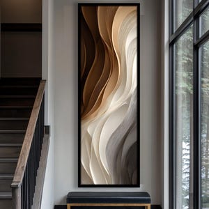 May include: Abstract wall art in a black frame. The artwork features flowing, layered shapes in shades of brown, beige, and white, creating a sense of depth and movement. The piece is displayed in a modern interior setting, adding a touch of elegance.