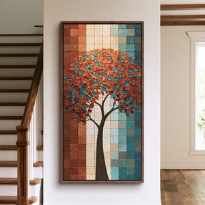 May include: A vertical rectangular wall art piece featuring a stylized tree with textured orange and teal leaves. The background consists of a grid of square tiles in gradient shades of brown, cream, and blue, all framed in dark wood.