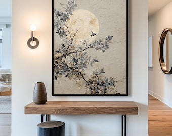 May include: A framed artwork featuring a tree branch with blue-grey leaves and a large, golden moon. A small bird flies near the moon. The artwork is displayed above a wooden console table with a dark vase and a black stool.