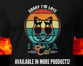 May include: A black t-shirt with a retro-style design featuring a cat wearing sunglasses and the text "Sorry I'm Late I Saw A Cat".