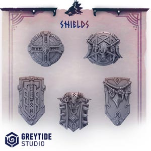 Può includere: Una collezione di cinque scudi grigi in miniatura con disegni intricati, tra cui rune, motivi geometrici e teschi di animali. La parola "SHIELDS" è visualizzata in testo blu sopra gli scudi. Il logo GreyTide Studio è in basso.