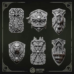 May include: A collection of six gray, intricately detailed shields. Designs include skulls, a lion's head, a woman holding a sword, and a sunburst. The shields are likely for tabletop gaming or decorative purposes.