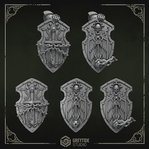 May include: A collection of five gray, ornate shields with detailed designs. Each shield features a central emblem, including skulls, swords, chains, and wings. The shields are likely for decorative or collectible purposes.