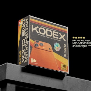 Puede incluir: Una caja de producto con el texto "KODEX" en rojo. La caja presenta un gráfico de teléfono naranja y las palabras "APPLE LOG FILM LOOK" y "ONE CLICK". La caja está sobre una superficie oscura.