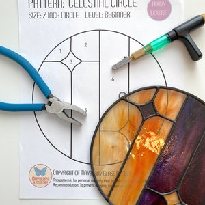 May include: A stained glass pattern for a 7-inch celestial circle with numbered sections. The pattern is printed on white paper with a hobby license label. The image also shows a stained glass piece in progress, a glass cutter, and pliers.
