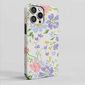 May include: A floral phone case featuring a cream background with a pattern of pastel-colored flowers. The design includes pink, purple, blue, and yellow blooms with green leaves. The case has a camera cutout and side buttons.
