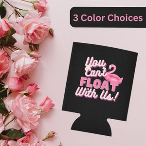 May include: Black can cooler with a pink flamingo and the text "You Can't Float With Us!" in white.