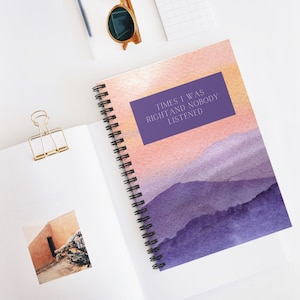May include: Spiral-bound notebook with a watercolor design featuring purple mountains and a pink and orange sky. The notebook has the text "TIMES I WAS RIGHT AND NOBODY LISTENED" in a purple rectangle.