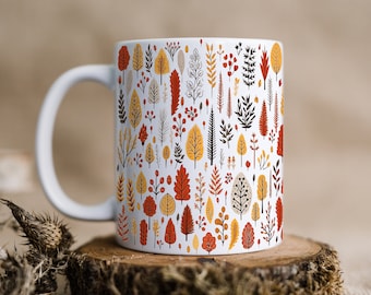 May include: White ceramic mug with a pattern of stylized trees, leaves, and berries in shades of orange, yellow, and brown.