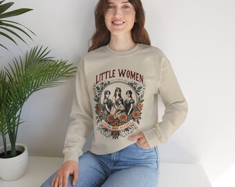 Könnte beinhalten: Beiges Sweatshirt mit dem Schriftzug "Little Women" in einem Vintage-Design. Die Grafik zeigt eine Illustration von vier Frauen, umgeben von Blumen. Das Sweatshirt hat lange Ärmel und einen Rundhalsausschnitt.