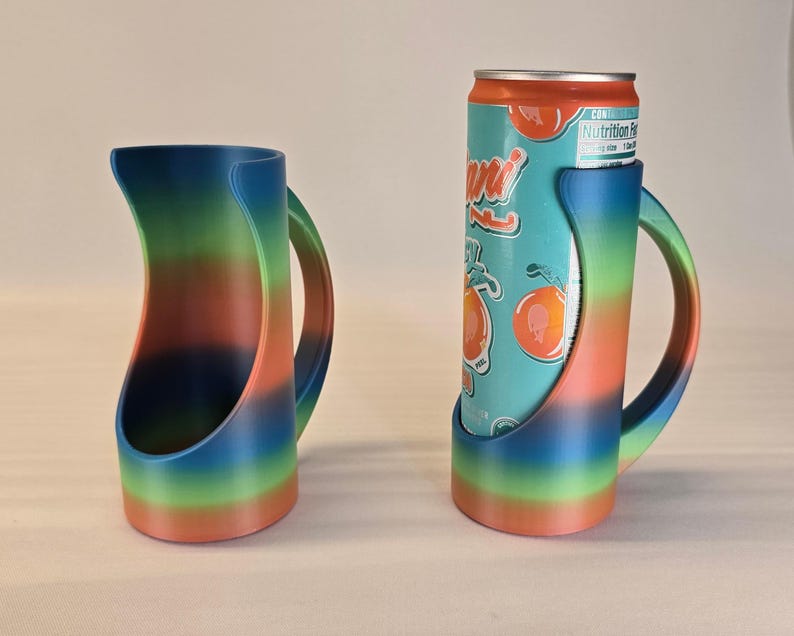 May include: A pair of rainbow-colored can holders. One holder is empty, the other holds a can of Arizona Iced Tea. The holders have a handle and a curved design, with a gradient of colors from blue to green to orange.