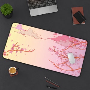 May include: A pink and yellow gradient mousepad with a design of cherry blossoms and clouds. The mousepad is on a black surface with a laptop, a cup of coffee, and a mouse.