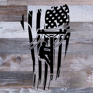 May include: Black and white silhouette of an electrician working on a power pole with an American flag in the background.