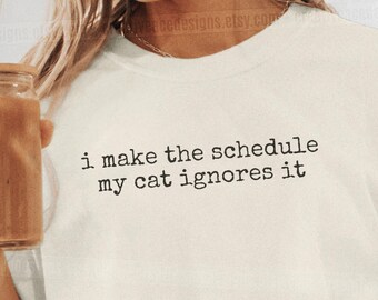 I Make The Schedule My Cat Ignores It Shirt Cat Mom Dad Gift Cat Humor Shirt Cat Mom Shirt Cat Dad Tee Gift For Cat Owners Four Legged Word