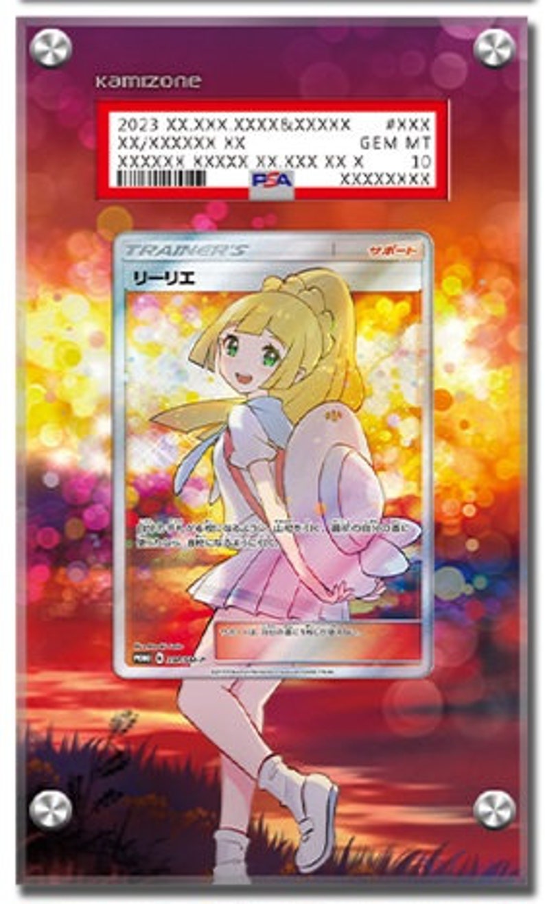 May include: A framed Pok&eacute;mon trading card featuring a character illustration. The card is encased in a clear acrylic holder with a red PSA label at the top. The card's artwork depicts a blonde-haired girl in a pink and white outfit. The background shows a sunset.