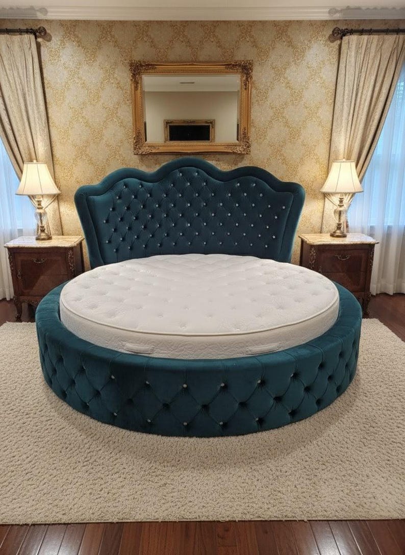 May include: A teal, round bed with a tufted headboard and base. The headboard has a scalloped top and is adorned with crystal-like buttons. A white mattress sits atop the bed frame. The bed is on a cream-colored rug.