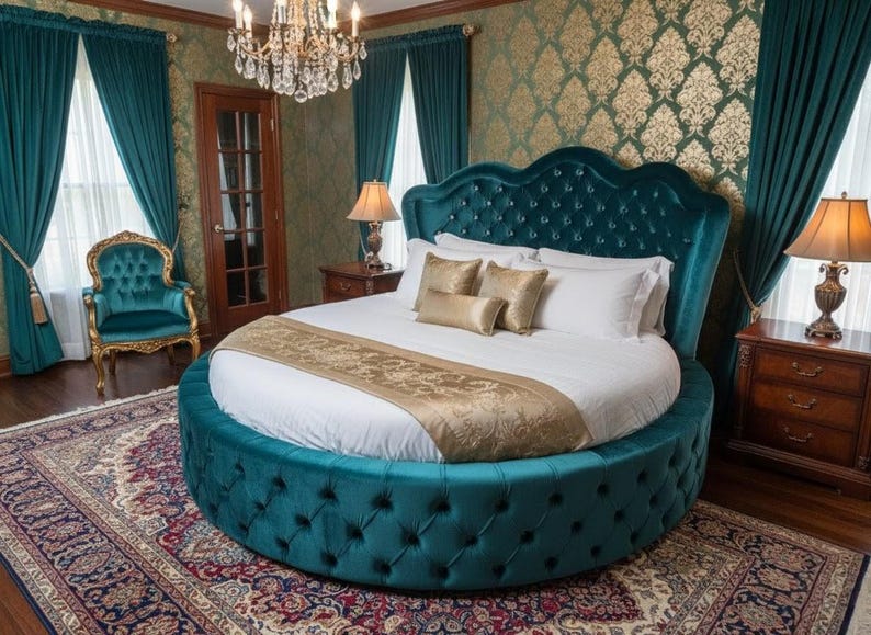 May include: A luxurious, round teal bed with a tufted headboard and base. The bed is adorned with white bedding, gold pillows, and a gold runner. The room features teal curtains, a patterned rug, and a chandelier, creating an elegant bedroom setting.