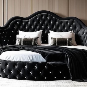 May include: A luxurious, round black bed with a tufted headboard and base. The headboard has a unique, scalloped shape and is adorned with crystal-like buttons. White pillows and a black blanket complete the elegant bedroom furniture.