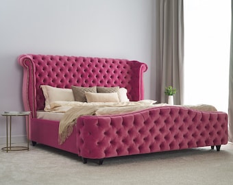 May include: A pink tufted headboard with a matching tufted footboard. The bed is made with white and brown pillows and a beige blanket.