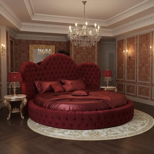 May include: A luxurious, round bed with a tufted, heart-shaped headboard and matching burgundy bedding. The room features a crystal chandelier, ornate side tables, and a patterned rug, creating an elegant bedroom setting.