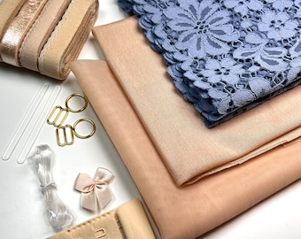 Puede incluir: Un conjunto de suministros para la elaboración de lencería que incluye dos piezas de tela beige, una pieza de encaje azul, dos cierres dorados, dos varillas de plástico transparente, un carrete de elástico beige, un carrete de elástico dorado, una pieza de elástico transparente y un cierre de sujetador beige.