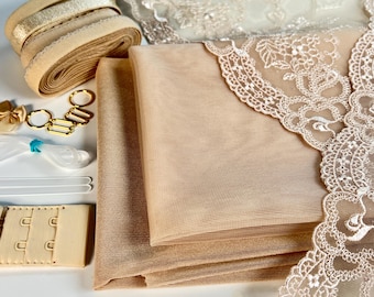 Puede incluir: Una colección de suministros de tela beige y dorada para coser o manualidades. Los suministros incluyen encaje, tul, elástico y cierres de sujetador.