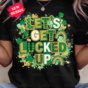 May include: Black t-shirt featuring a St. Patrick's Day theme. The phrase "LET'S GET LUCKED UP" is displayed in green, gold, and white, with shamrocks, rainbows, and leprechaun hats. A "NEW DESIGN" label is in the upper left.
