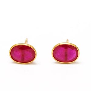 May include: A pair of gold oval stud earrings with red ruby gemstones.