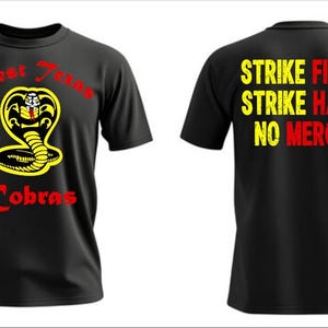 Puede incluir: Camiseta negra con el logo de Cobra Kai, una cobra amarilla y las palabras "West Texas Cobras" en rojo. La parte trasera de la camiseta muestra el texto "Strike First, Strike Hard, No Mercy" en amarillo y rojo.