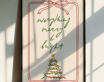 May include: Framed art print in a black frame. The print displays the words "everything merry & bright" in green script, a red bow, and a Christmas tree illustration. The artwork is set against a white backdrop.