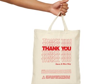 May include: A white canvas tote bag with red text that says "Thank You" repeated multiple times. The bag also has the text "Have A Nice Day" and a warning about plastic bags.