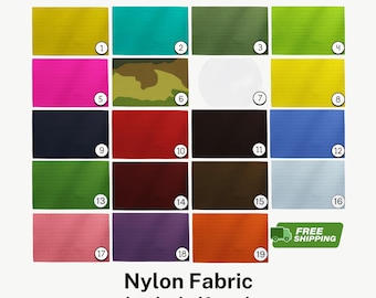 May include: A grid of nineteen rectangular swatches of nylon fabric in various solid colors and one camouflage pattern, each labeled with a numbered circle from 1 to 19. The text Nylon Fabric by the half yard is printed at the bottom.