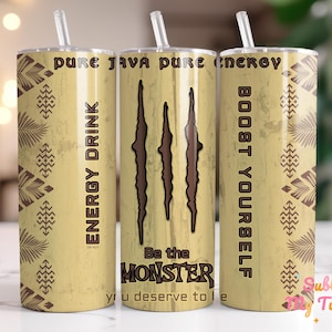 Może przedstawiać: Żółto-brązowy kubek ze słomką, z napisem "PURE JAVA PURE ENERGY" i "ENERGY DRINK". Projekt zawiera ślady pazurów i słowa "Be the MONSTER". Obecne są również wzory dekoracyjne.