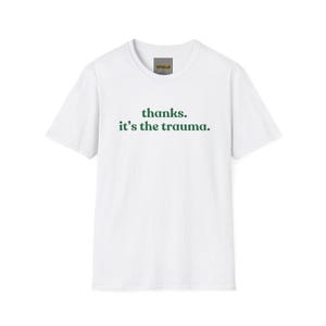 Könnte beinhalten: Weißes T-Shirt mit grünem Text, der "thanks. it's the trauma." lautet.