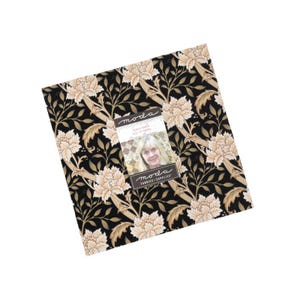 May include: A square fabric bundle with a floral pattern in cream and gold on a black background. The fabric features large peony-like flowers and foliage. A tag with a woman's image and the Moda Fabrics logo is attached.