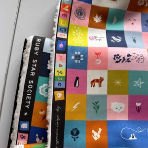 Può includere: Tessuto colorato con un design patchwork con varie icone e illustrazioni in quadrati. Il tessuto include il testo "RUBY STAR SOCIETY" e "SELVEDGE". Il design include una varietà di colori, tra cui rosa, blu, giallo e arancione.