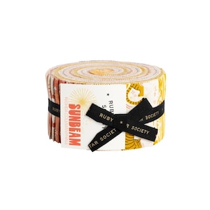 May include: A rolled bundle of fabric strips in various patterns and colours, including red, yellow, and white. The bundle is secured with a black ribbon and a label that reads "Sunbeam" and "Ruby Star Society."