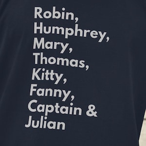May include: A navy blue t-shirt with white text that reads "Robin, Humphrey, Mary, Thomas, Kitty, Fanny, Captain & Julian".