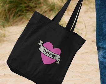 May include: Black tote bag with a pink heart and the word "feminist" on a banner.