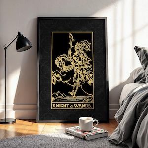 May include: A framed art print depicting the Knight of Wands tarot card. The gold illustration of a knight on horseback is set against a black background. The text "KNIGHT of WANDS" is displayed in gold.
