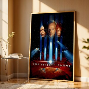 Peut inclure: Affiche encadrée du film "Le Cinquième Élément" avec trois portraits de personnages et une scène futuriste avec des faisceaux de lumière bleus et des véhicules volants. Le titre est en blanc en bas.