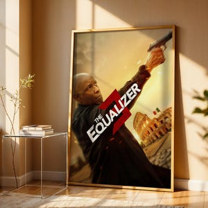 Peut inclure: Affiche encadrée du film "The Equalizer 3" avec Denzel Washington tenant une arme à feu. L'affiche a un cadre doré et le titre est en blanc et rouge. L'arrière-plan montre le Colisée et un coucher de soleil.